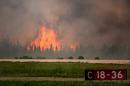 In this July 5, 2015 photo, flames rise from a wildfire near La Ronge, Saskatchewan. Canadian soldiers arrived Tuesday, July 7 to help battle raging wildfires, where about 13,000 people have been evacuated in recent days. (Corey Hardcastle/Ministry of the Environment/Government of Saskatchewan via AP)
