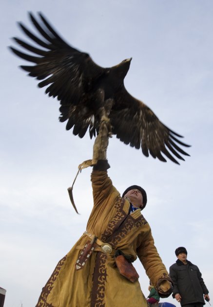 A hunter releases his tame golden eagle during an annual hunting competition outside Almaty