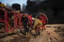 Workers assemble a water pipeline to put out the fire in an oil well set ablaze by retreating Islamic State jihadists in Qayyarah, near Mosul, on November 20, 2016