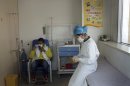 A nurse stays with a patient at a specialized fever clinic inside the Ditan Hospital, where a Chinese girl warded for the H7N9 strain of bird flu, in Beijing Saturday, April 13, 2013. The 7-year-old girl has become the first confirmed case in Beijing of the latest strain of bird flu virus, which has killed 11 and sickened 34 others in eastern China, officials said Saturday. (AP Photo) CHINA OUT