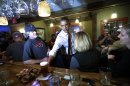 President Barack Obama reaches for his beer from the bar as he greets local patrons during an unscheduled visit to the Common Man Merrimack restaurant, Saturday, Oct. 27, 2012 in Merrimack, NH. (AP Photo/Pablo Martinez Monsivais)