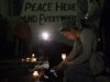 Samantha Lacovara takes pictures of a banner mourners were signing during a candlelight vigil for bomb victims in Boston