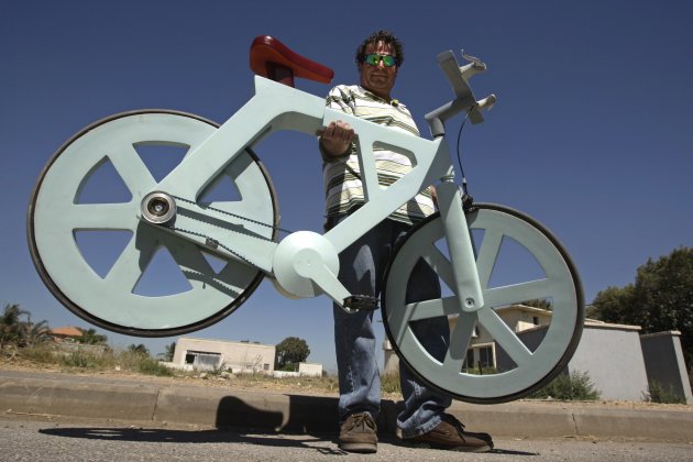 Israeli inventor Izhar Gafni holds his cardboard bicycle as he poses for a photo in Moshav Ahituv, central Israel September 24, 2012. The bicycle, made almost entirely of cardboard, has the potential to change transportation habits from the world's most congested cities to the poorest reaches of Africa, Gafni, an expert in designing automated mass-production lines and an amateur cycling enthusiast, says. Picture taken September 24, 2012. To match ISRAEL-CARDBOARDBIKE/     REUTERS/Baz Ratner (ISRAEL - Tags: ENVIRONMENT SPORT CYCLING SOCIETY)