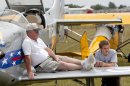 FILE - In this July 27, 2009, file photo, Lanny Rundell of Winnsboro, La. and his grandson Cole Uffman take a rest on their plane at the Experimental Aircraft Association's AirVenture in Oshkosh, Wis. One of the nation's largest air shows begins Monday, July 29, 2013, in Wisconsin, and for each of the 10,000 planes flying in, the federal government will collect about $45 for air traffic control services. The fee has angered pilots, who already pay for air traffic control through a fuel tax. (AP Photo/Mike Roemer, File)
