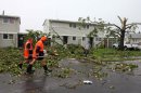 Emergency workers walk through debris in Auckland, New Zealand, following a tornado Thursday, Dec. 6, 2012. A small tornado ripped through the city, leaving at least three people dead. (AP Photo/New Zealand Herald, Chris Gorman) AUSTRALIA OUT, NEW ZEALAND OUT