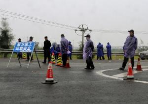 Officials check vehicles leading to the town of Oubei, …