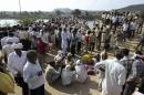 Indian villagers gather after a deadly stampede on a bridge across the Sindh River in Datia district in Madhya Pradesh state, India, Sunday, Oct. 13, 2013. A stampede by masses of Hindu worshippers left scores of people dead on a bridge they had been crossing to reach a temple in central India, police said. (AP Photo)