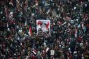 Egyptians wave the national flag and hold up pictures of Defence Minister army chief Abdel Fattah al-Sisi in Cairo's Tahrir Square during a rally marking the anniversary of the 2011 Arab Spring uprising on January 25, 2014