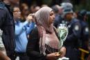 A Muslim woman queues up to lay flowers at a makeshift memorial near the scene of a fatal siege in Sydney's financial district on December 16, 2014