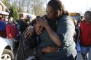 A woman comforts a child after after a shooting at an Price Middle school in Atlanta on Thursday, Jan. 31, 2013. A 14-year-old boy was wounded outside the school Thursday afternoon and a fellow student was in custody as a suspect, authorities said. No other students were hurt. (AP Photo/John Bazemore)