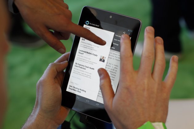 Attendees interact with a Google Nexus 7 tablet during Google I/O 2012 Conference at Moscone Center in San Francisco