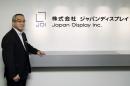 Homma poses in front of the company's logo at its headquarters in Tokyo