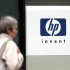 File photograph of a woman walking past the Hewlett Packard logo at its French headquarters in Issy le Moulineaux