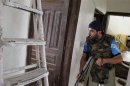 A Free Syrian Army fighter takes refuge in an apartment during clashes with forces loyal to Syria's President Assad in the centre of Aleppo
