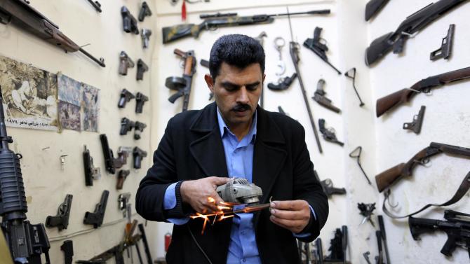 In this Wednesday, Feb. 25, 2015 photo, gunsmith Bahktiyar Sadr-Aldeen repairs a weapon at his shop, in Irbil, northern Iraq. Sadr-Aldeen doesn’t limit his work to his shop. Sometimes he goes out to the front lines himself, mostly to repair heavy weapons that can’t be transported. The peshmerga send a car and take him out to the front to do his work. (AP Photo/Bram Janssen)