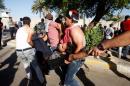 Anti-government protesters carry a man injured during the storming of Baghdad's Green Zone in Iraq