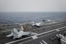 A pair of US Navy F/A-18 Super Hornet aircraft prepare to take-off from the flight deck of the USS George Washington some 300kms off the coast of Hong Kong, on June 15, 2014