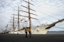Port workers walk past the three-masted ARA Libertad, a symbol of Argentina's navy, as it lies docked at the port in Tema, outside Accra, Ghana, Tuesday, Oct. 23, 2012. Argentina has hired an Air France charter to fly nearly 300 navy cadets home from Ghana after failing to persuade the government there to reverse the seizure of its tall ship. Argentina said Monday that 281 crew members from Argentina and a half-dozen other countries will fly to Buenos Aires on Wednesday, leaving the captain with a skeleton crew to maintain the ship at port in Ghana.(AP Photo/Gabriela Barnuevo)