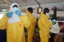 Health workers with 'Doctors Without Borders' put on protective equipment at an Ebola isolation ward of the Donka Hospital in Conakry, on June 28, 2014