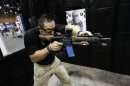 An exhibitor fires a dummy AR-15 style assault weapon at the seventh annual Border Security Expo in Phoenix
