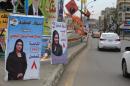 Vehicles drive past campaign banners showing election candidate Iraqi Sabah abed al-Rasul al-Tamimi in the capital Baghdad, on April 15, 2014