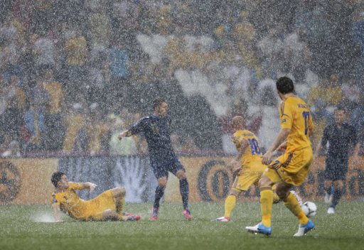 France's Jeremy Menez is surrounded by Ukraine's players as rain falls during their Group D Euro 2012 soccer match at Donbass Arena in Donetsk