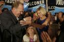 San Diego mayoral candidate Kevin Faulconer reaches for his wife, Katherine, as their daughter looks up from below after Faulconer addressed his supporters at a rally Tuesday, Feb. 11, 2014, in San Diego. (AP Photo/Lenny Ignelzi)