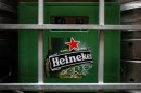 A plastic container with empty bottles of Heineken beers are pictured among beer kegs outside a restaurant in Singapore