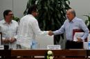 FARC-EP leftist guerrilla commander Ivan Marquez (C) and the head of the Colombian delegation for peace talks Humberto de la Calle (R) shake hands after signing a new peace agreement in Havana, on November 12, 2016
