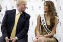 Donald Trump, left, and Miss Universe, Gabriela Isler, of Venezuela, talk during a news conference, Thursday, Oct. 2, 2014, in Doral, Fla. Three of the last six Miss Universe titles have gone to Venezuelan contestants. This year's Miss Universe competition has a unique undertone: It will take place in South Florida, home to the largest number of Venezuelans in the U.S., the majority strongly against the current Venezuelan government. (AP Photo/Wilfredo Lee)