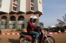 A man drives a motorcycle past the Radisson Blu hotel in Bamako