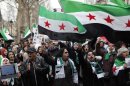 Demonstrators wave Syrian flags as they chant slogans during a march to mark the second anniversary of the revolt against the Syrian government of President Bashar Assad, in Paris, Saturday, March 16, 2013. The French President Francois Hollande said Thursday his country and Britain are pushing the European Union to quickly lift its arms embargo on Syria so that they can send weapons to rebel fighters. (AP Photo/Thibault Camus)
