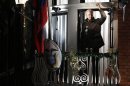 WikiLeaks founder Julian Assange gestures from the balcony of Ecuador's Embassy as he makes a speech, in central London