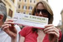 An activist of Five Star Movement holds a facsimile of a check during a demonstration called "Restitution Day", in front of the Italian parliament in Rome