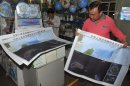 In this Sept. 19, 2012 photo, a costumer picks copies of newly-published maps of disputed islands, called Diaoyu in China and Senkaku in Japan, at a state-owned book store in Beijing, China. China hastily published the map to help maintain public outrage over the Japanese government's purchase of some of the islands from their private Japanese owners. Beijing also has engaged in another type of mapmaking that may end up escalating the conflict. (AP Photo) CHINA OUT