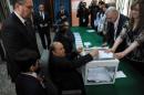 Algeria's ailing President Abdelaziz Bouteflika (C), running for re-election, casts his ballot from a wheelchair at a polling station in Algiers on April 17, 2014