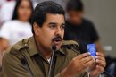 Venezuela's acting President and presidential candidate Maduro holds a copy of the Venezuelan constitution as he speaks during a ceremony with students in Caracas