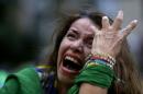A Brazil soccer fan cries as Germany scores against her team at a semifinal World Cup match as she watches the game on a live telecast in Belo Horizonte, Brazil, Tuesday, July 8, 2014. (AP Photo/Bruno Magalhaes)
