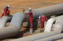 FILE PHOTO: Oil workers weld a pipeline at PDVSA's Jose Antonio Anzoategui industrial complex in the state of Anzoategui
