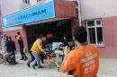 Emergency services evacuate an injured man on a stretcher on January 18, 2016 after mortar shells landed near a school in Kilis