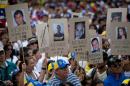 Demonstrators hold up posters with images of Venezuelans who were killed in the past two weeks during the recent unrest, at a rally with human rights activists in Caracas, Venezuela, Friday, Feb. 28, 2014. The start of a weeklong string of holidays leading up to the March 5 anniversary of former President Hugo Chavez's death has not completely pulled demonstrators from the streets as the government apparently hoped. President Nicolas Maduro announced this week that he was adding Thursday and Friday to the already scheduled long Carnival weekend that includes Monday and Tuesday off, and many people interpreted it as an attempt to calm tensions. (AP Photo/Rodrigo Abd)