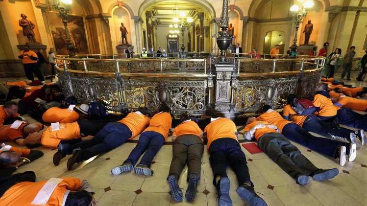 FILE - In this April 16, 2013 file photo, members of the Community Renewal Society from Chicago participate in a "die-in" protest to stop gun violence and support legislation to stop illegal gun trafficking and stronger laws for gun registration, in front of Illinois Gov. Pat Quinn's office at the Illinois State Capitol in Springfield. As Quinn mulls whether to sign off on eliminating the nation’s last ban on public possession of guns, the question in Chicago is whether it will matter in the crime-weary city where a spiking murder rate drew national attention last year. (AP Photo/Seth Perlman, File)