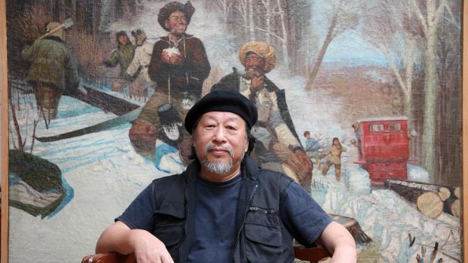 In this picture taken Thursday, Jan. 29, 2015, Chinese-Australian artist Jiawei Shen sits next to some of his works in his studio in Bunbeena, Australia. Artist Shen Jiawei's paintings of Chinese soldiers during the Cultural Revolution were so popular with Mao's regime that 250,000 copies of his most famous work were made into propaganda posters and distributed throughout the country. Four decades later, Shen now has a different patron commissioning his work: He has become, somewhat inexplicably, the unofficial portrait artist of the Vatican. He painted the first official portrait of Pope Francis and recently completed a huge rendition of the second most powerful man in Rome, Cardinal George Pell, the Vatican's money guy. (AP Photo/Rick Rycroft)