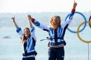 Great Britain's Hannah Mills (L) and Saskia Clark celebrate on the podium after winning silver in the women's sailing 470 two-person dinghy at the London 2012 Olympic Games in Weymouth on August 10, 2012