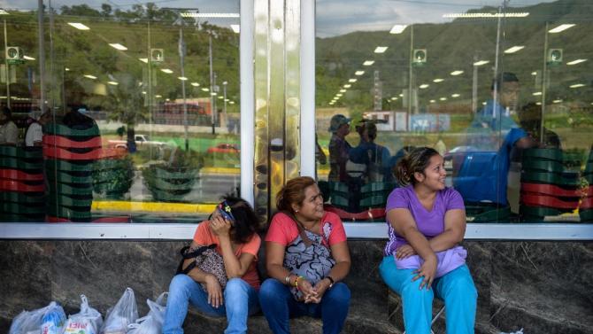People queue outside a supermarket in Valencia, 180 km west of Caracas, on August 11, 2015