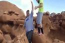FILE - This file frame grab from a video taken by Dave Hall shows two men cheering after a Boy Scouts leader knocked over an ancient Utah desert rock formation at Goblin Valley State Park. Prosecutors have filed charges Friday Jan. 31, 2014, against two former Boy Scout leaders accused of toppling ancient rock formations at Utah's Goblin Valley State Park. State Parks officials say Glenn Taylor was charged with criminal mischief. David Hall was charged with aiding criminal mischief, another felony. (AP Photo/Dave Hall, File)