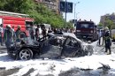 This photo released by the Syrian official news agency SANA, shows Syrian fire fighters extinguishing burning cars after a car bomb exploded in the capital's western neighborhood of Mazzeh, in Damascus, Syria, Monday, April. 29, 2013. State-run Syrian TV says the country's prime minister has escaped an assassination attempt when a bomb went off near his convoy. The TV says Prime Minister Wael al-Halqi was unhurt in the attack in the capital's western neighborhood of Mazzeh. (AP Photo/SANA)