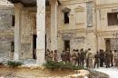 Syrian troops stand next to a mansion in the ancient city of Palmyra on March 24, 2016