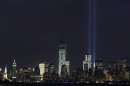 The Tribute in Light rises above the lower Manhattan skyline and One World Trade Center, center, in a test of the memorial light display, Monday, Sept. 9, 2013 in New York. The twin beams of light will also appear Wednesday, Sept. 11, twelve years after the terrorist attacks of Sept. 11, 2001. The Statue of Liberty and Empire State Building are at far left. (AP Photo/Mark Lennihan)
