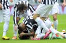 Juventus defender Kwadwo Asamoah, of Ghana, on the ground, is celebrated by his teammates after scoring during a Serie A soccer match between Juventus and Chievo Verona, at the Juventus stadium, in Turin, Italy, Sunday, Feb. 16, 2014. (AP Photo/Massimo Pinca)